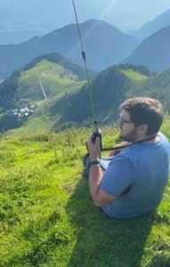 Funkamateur mit Handfunkgerät und Antenne am Berggipfel — SOTA Portabelbetrieb in Kärnten