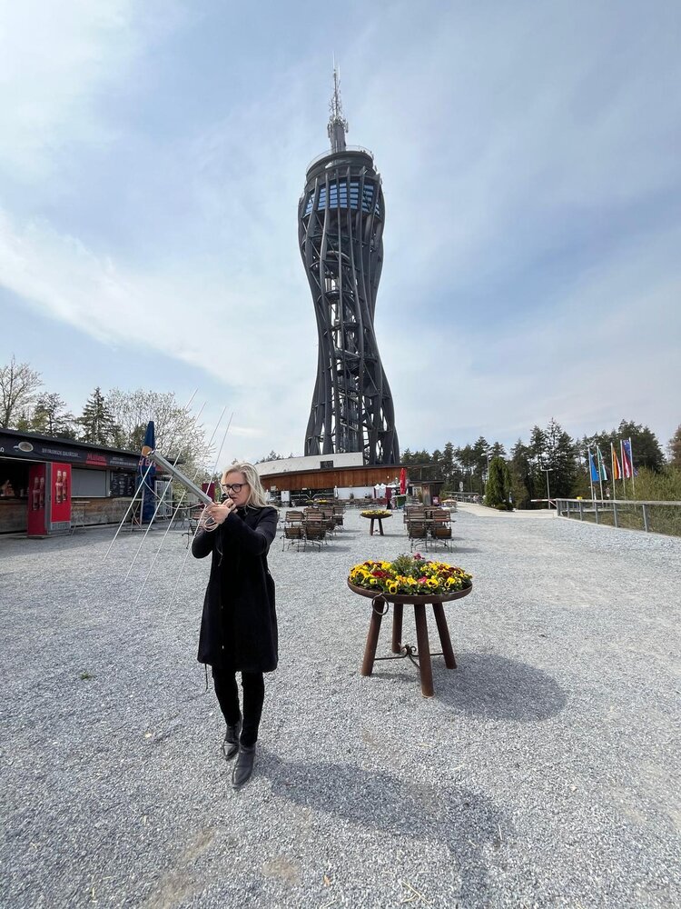 Gerlinde OE8GSY operating portable in front of the Pyramidenkogel tower
