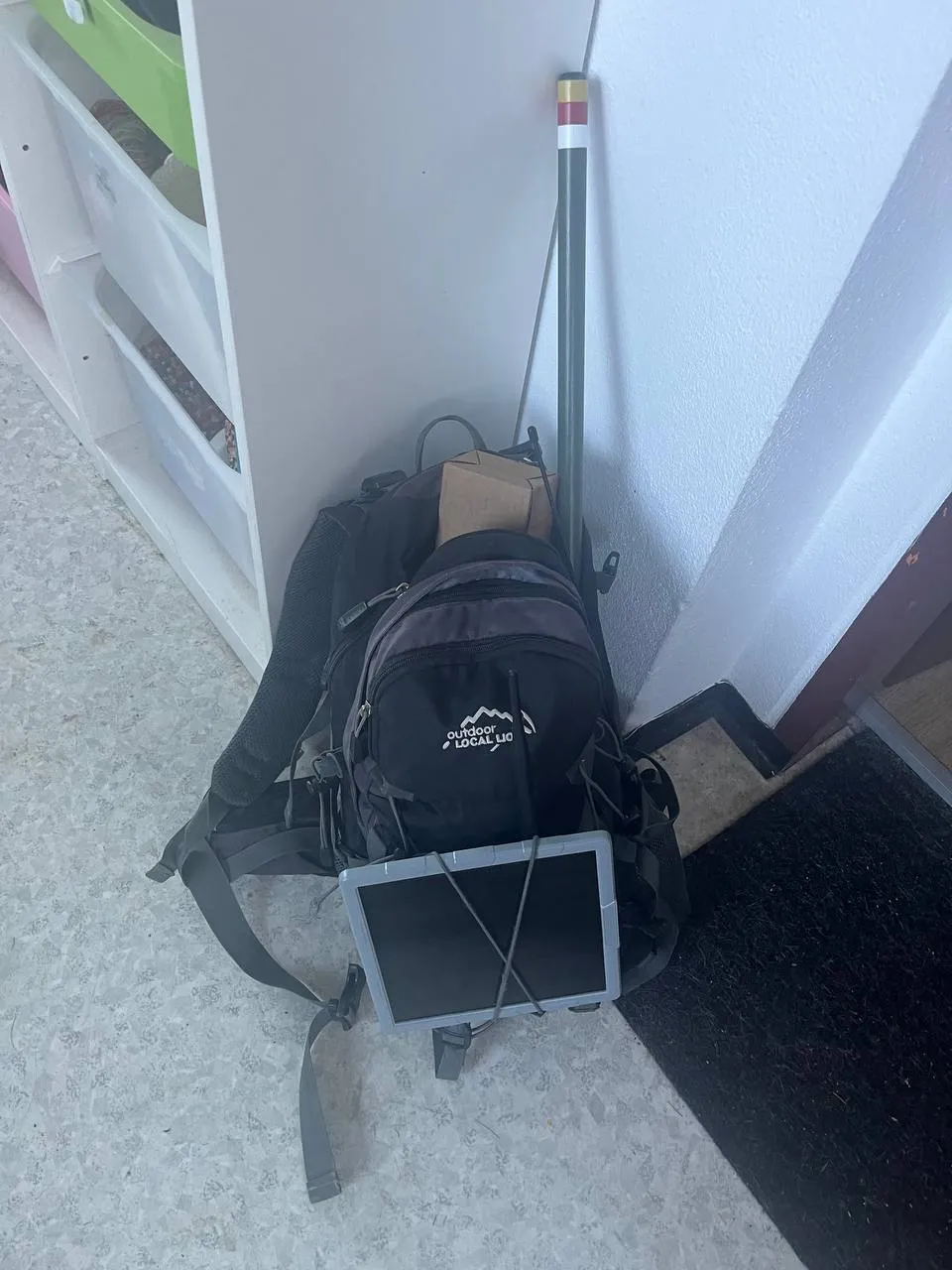 Gepackter Rucksack mit Antennenmast, Solarpanel und Gerätekarton, bereit für den Aufstieg