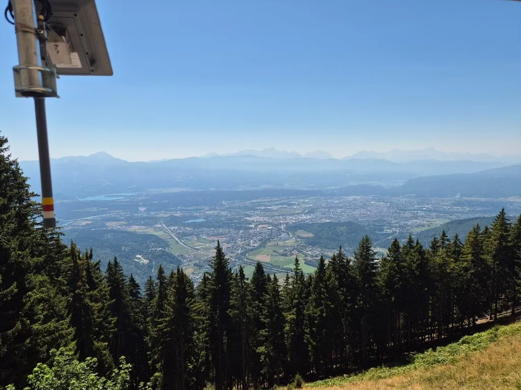 Solarpanel und Antenne des Gerlitzen-Knotens am Mast, dahinter der Blick über das Villacher Becken bis zu den Karawanken
