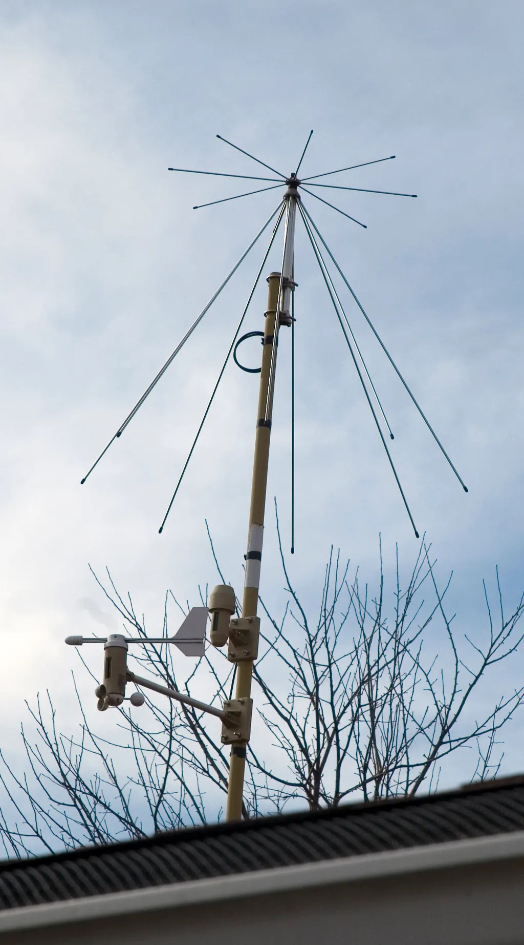 Discone-Antenne auf einem Mast, daneben eine Wetterstation