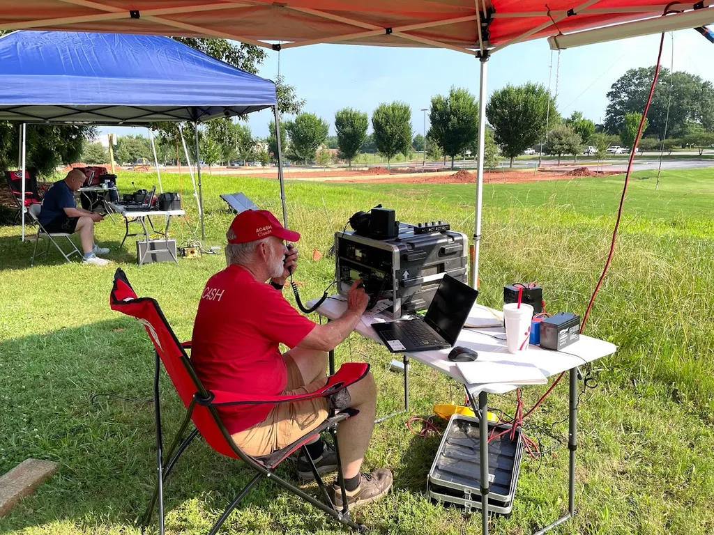 Field-Day-Station unter Pavillons mit Tisch, Laptop und Transceiver