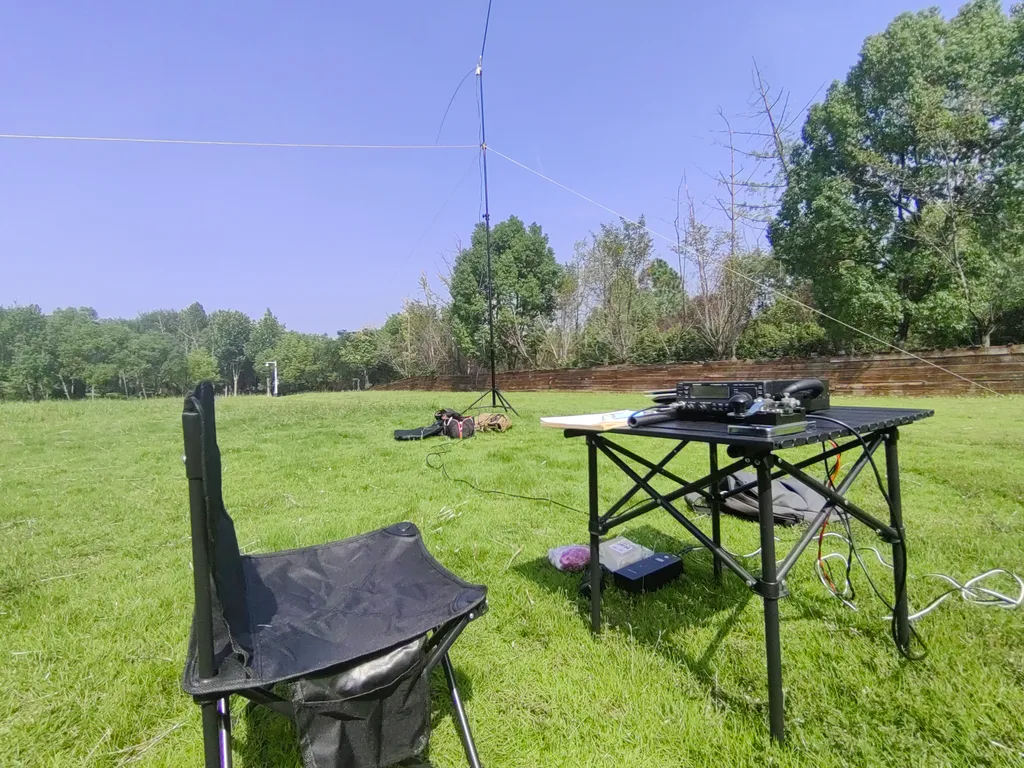 Portable Vertikalantenne und Klapptisch auf einer Wiese