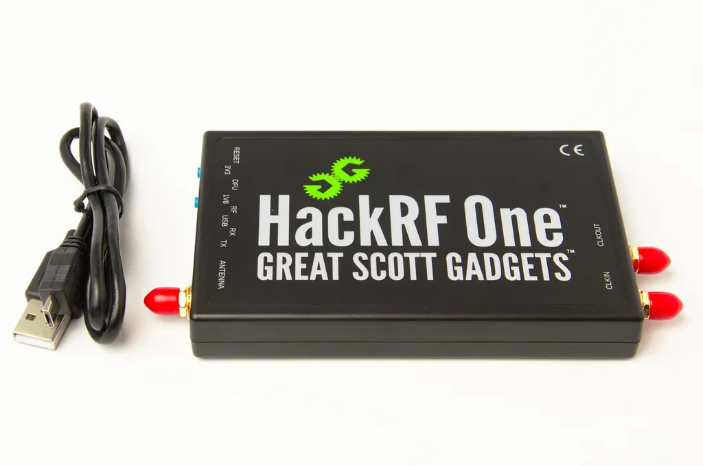 HackRF One v černém plastovém pouzdru s červenými konektory SMA a kabelem USB